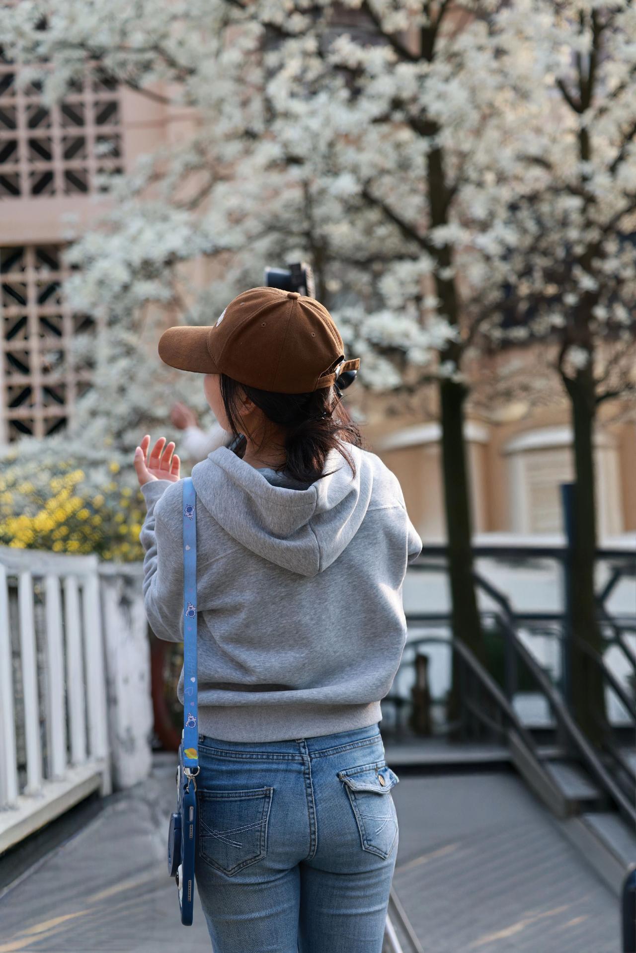 举起相机，捕捉春日限定温柔。阳光落在背影上，一身简单卫衣牛仔裤，搭配可爱宇航员平