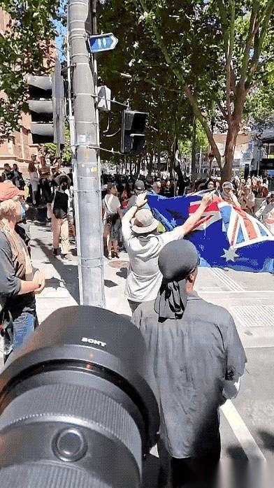 墨尔本街头那段视频，看得人后背发凉。一个男人，就因为手里举着一面澳大利亚国旗，