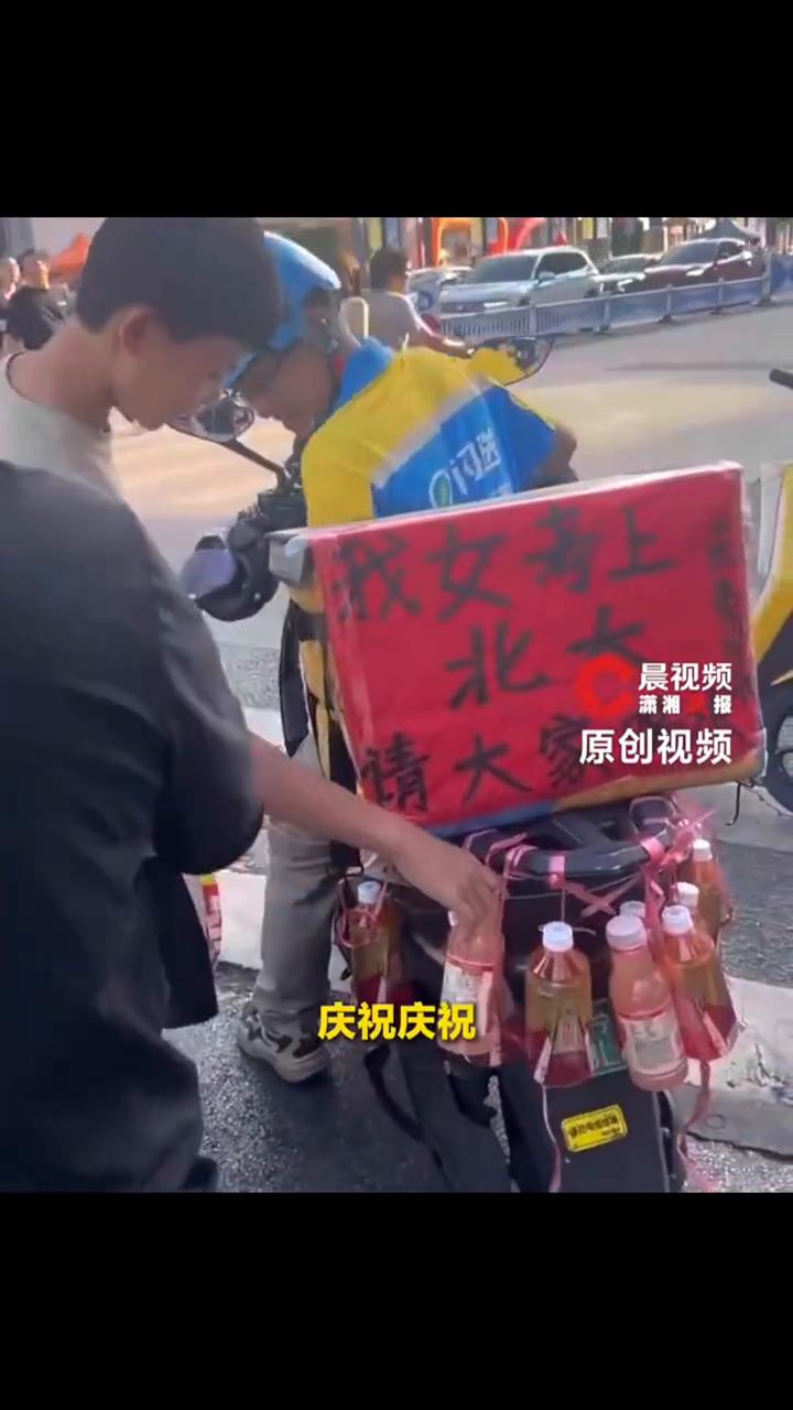 骑手因女儿考上北大请路人喝水。当事人：女儿已收到录取通知书，在车上挂满饮料免费请