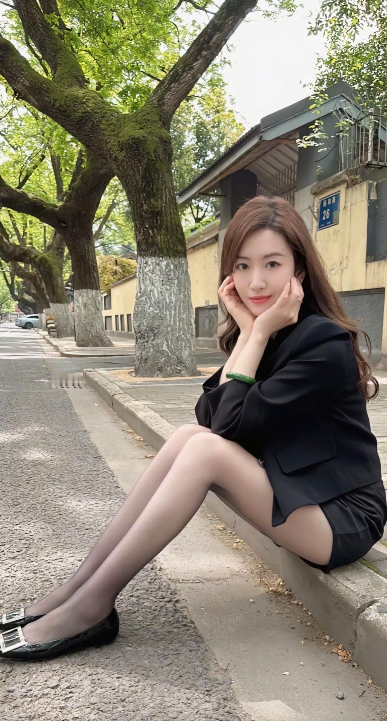 都市女孩的优雅瞬间，黑西装与绿树相映成趣。