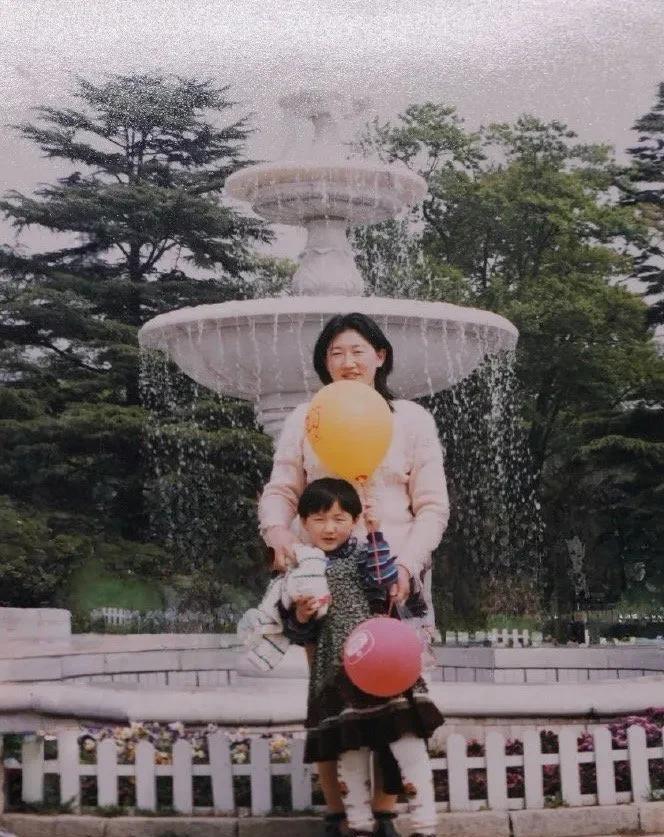 这是陈梦六七岁时和妈妈在公园里的一张珍贵合影。图中陈梦的妈妈体态丰盈，一头乌发