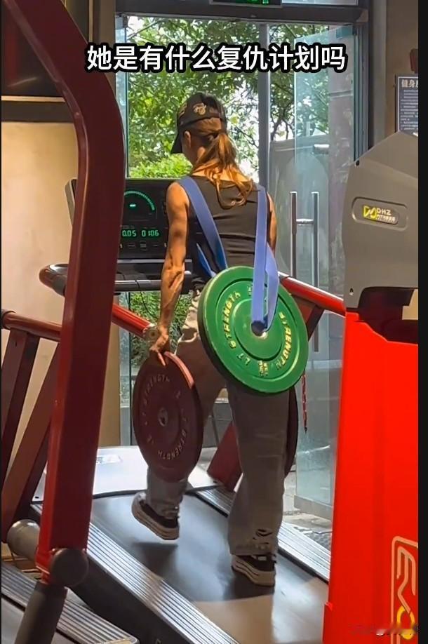 我想她是位妈妈，靠自己养活孩子的妈妈，背上背孩子，两手要搬砖。这杠铃片不是配