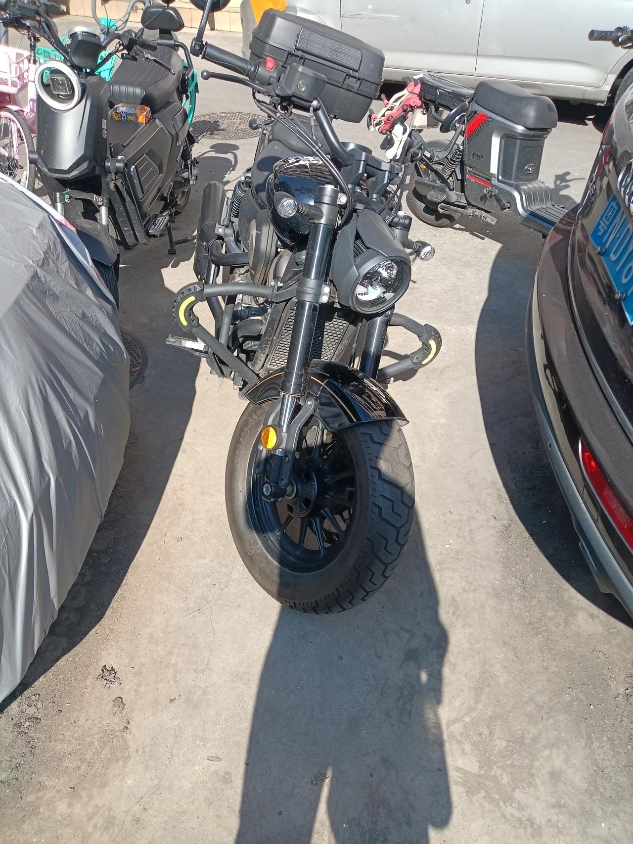 广州海珠区城中村街头，一台大排量的摩托车格外显眼，看起来很很新。轮胎都没灰