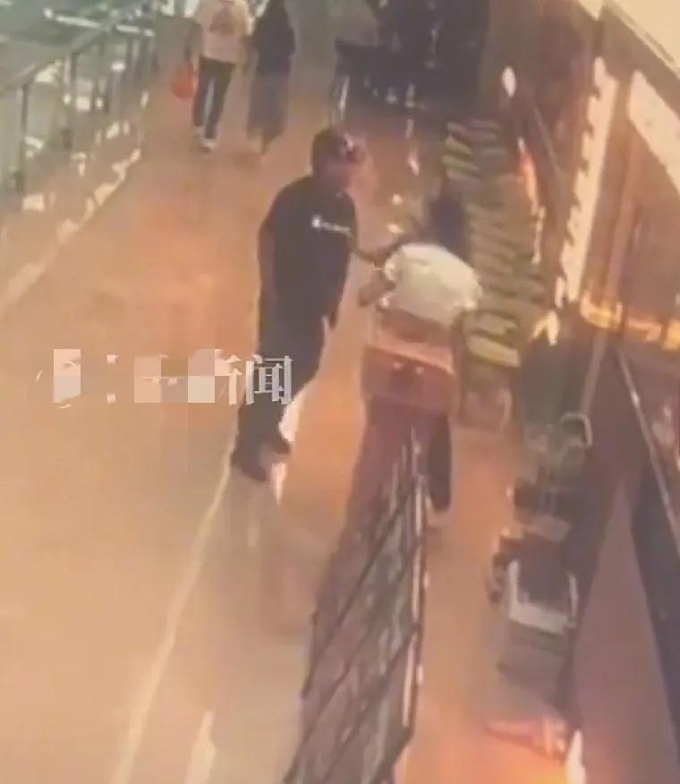 5月27日，在湖北襄阳，一位头戴头盔，身体强壮的中年男子性骚扰一家超市的女店员，