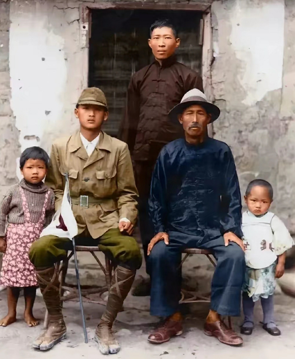 1943年，一名被强征的台湾少年身着日军制服与家人合影，稚嫩脸庞难掩茫然。二战期