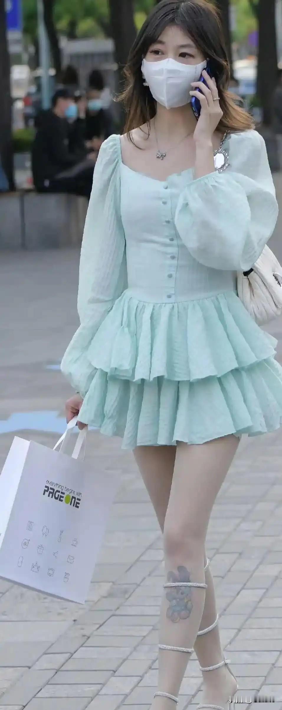 穿着淡蓝色裙子的女孩在打电话。