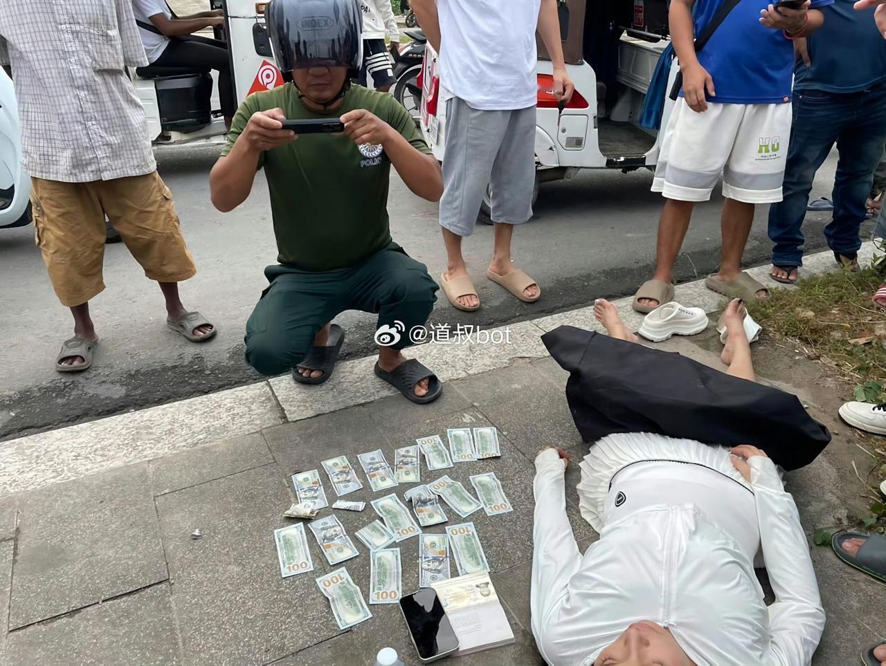 柬埔寨西港街头一中国女子横躺街头，身边撒满美金100元大钞，钱竟然没有被人捡走，