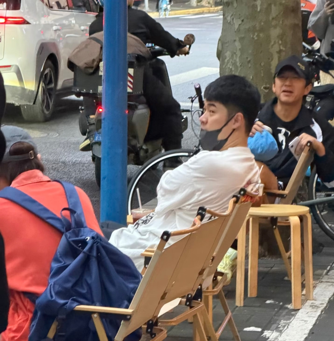 邓超与陈赫在上海外出被偶遇，兄弟俩的穿着和状态都非常松弛，坐在车水马龙的街边小椅子上喝咖啡，陈赫素颜