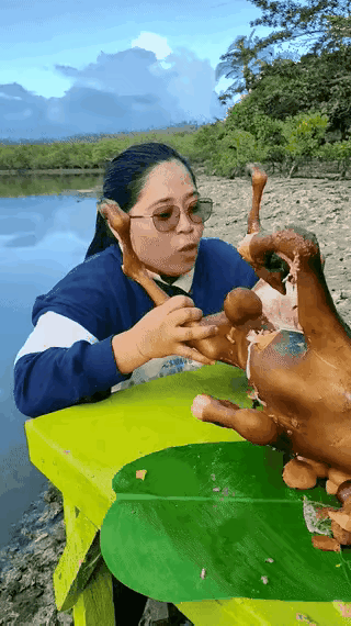 这位大姐多久没吃过这么好吃的香肉了吧。，只见她捧起整只狗，一口两口咬下去，满嘴流