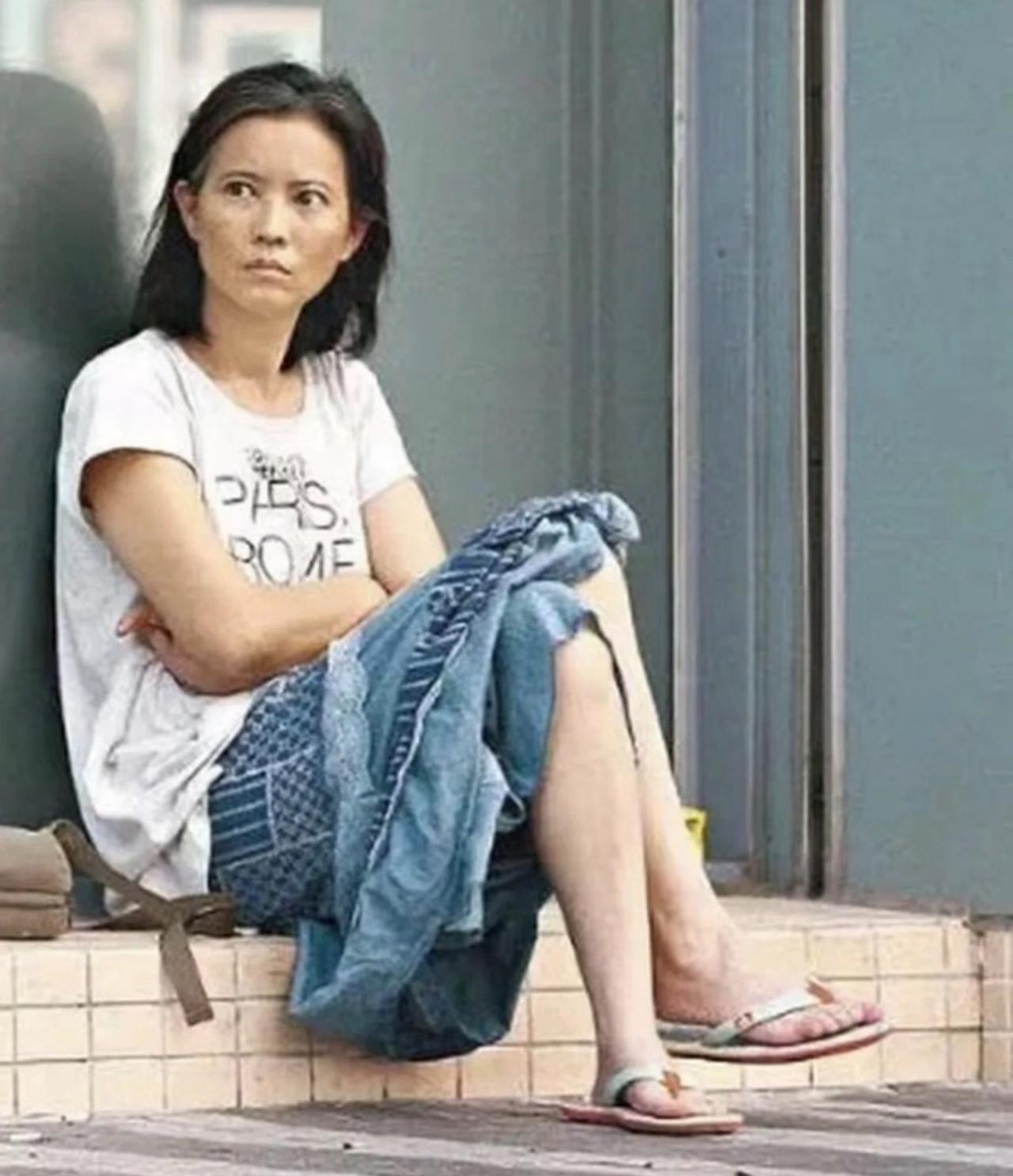 拍这张照片的时候，蓝洁瑛已经过得很落魄了，当时的她衣着随意的坐在街边牙子上，眼神