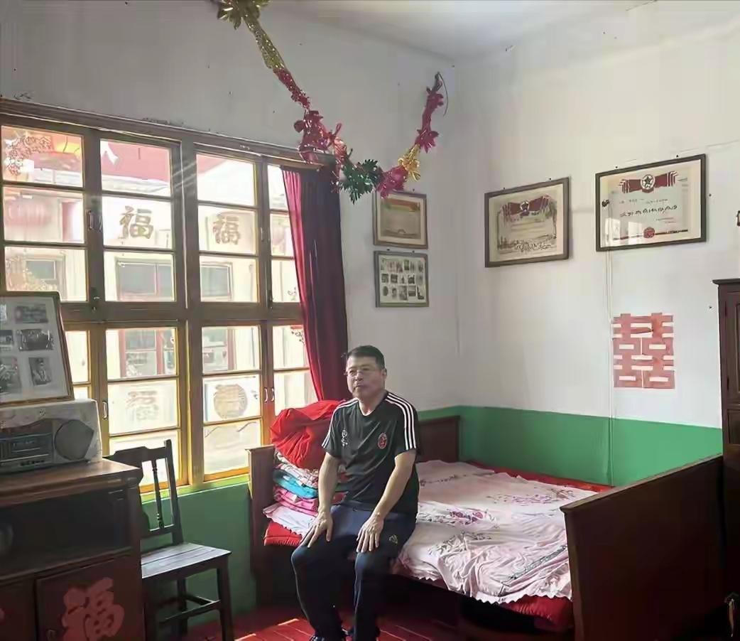 看到网上有人发表了一张央视前主持人阿丘坐在老房子里的照片，门窗还是木头的，看来生