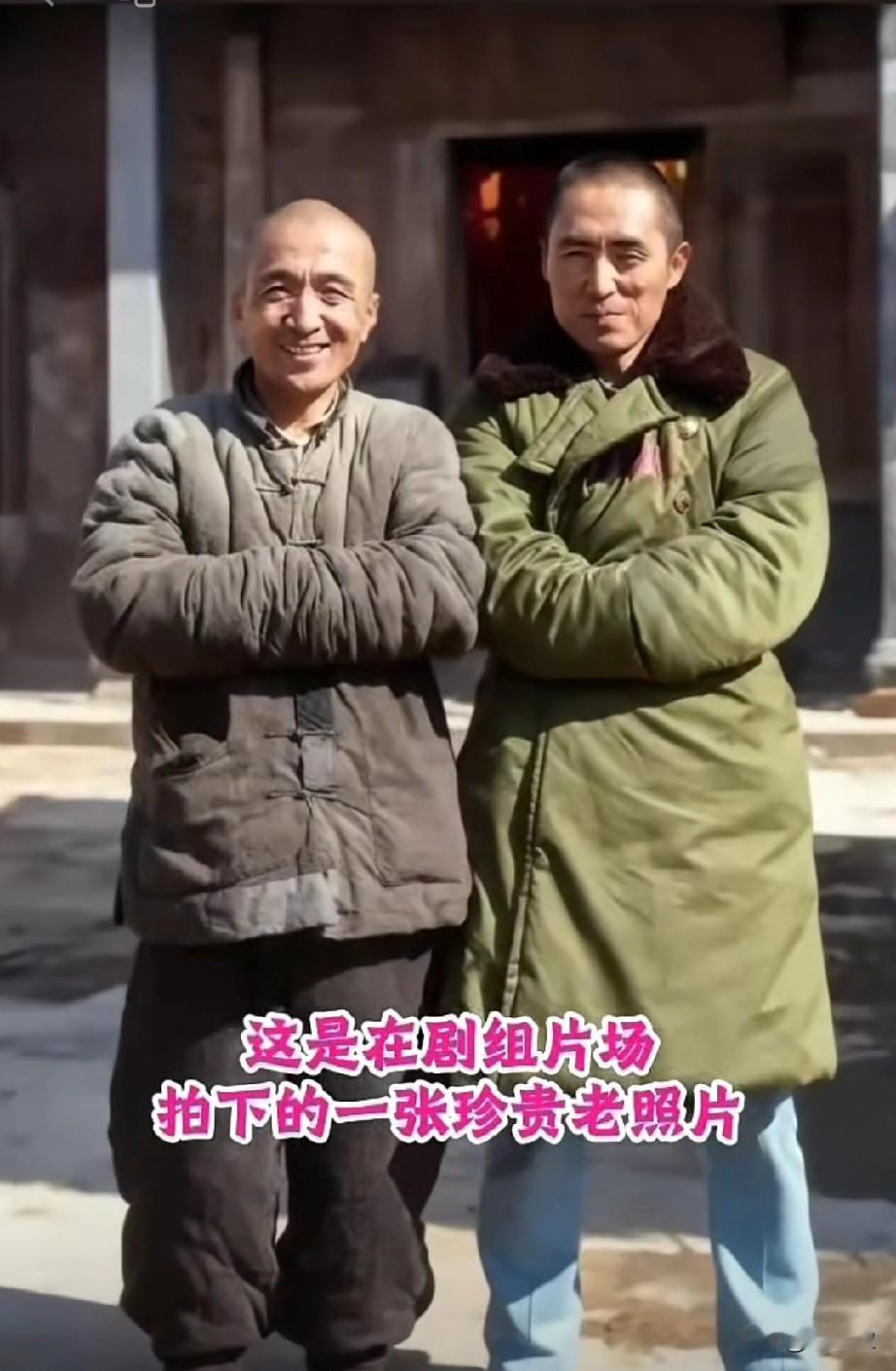 这是在剧组片场拍下的一张珍贵老照片，他们双臂交叉并肩而立。左侧男士身着老式棉
