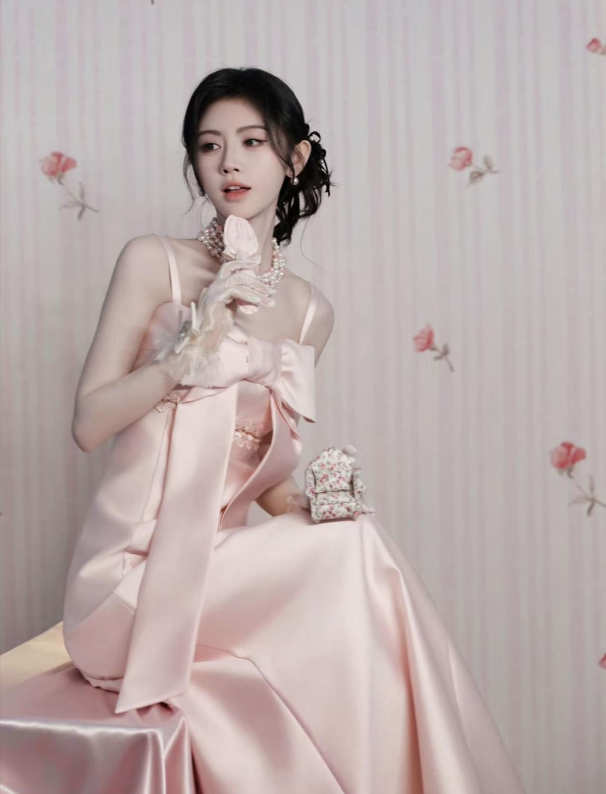 温柔氛围感拉满，鞠婧祎身着浅粉色蝴蝶结礼服，绸缎面料柔和高级，举手投足尽显优雅气