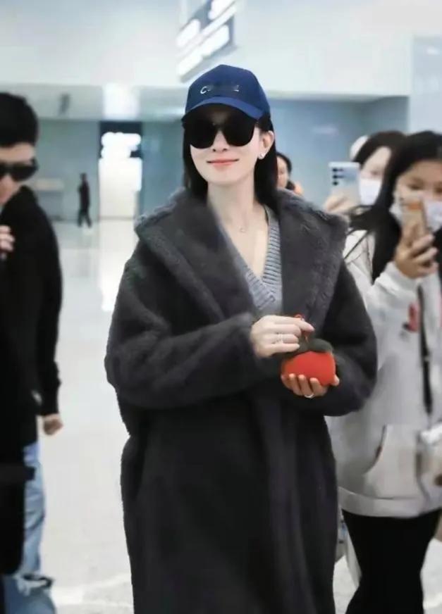 佘诗曼的机场私服，把“松弛感”焊在了身上！一件深灰色的羊羔毛大衣，内搭简约
