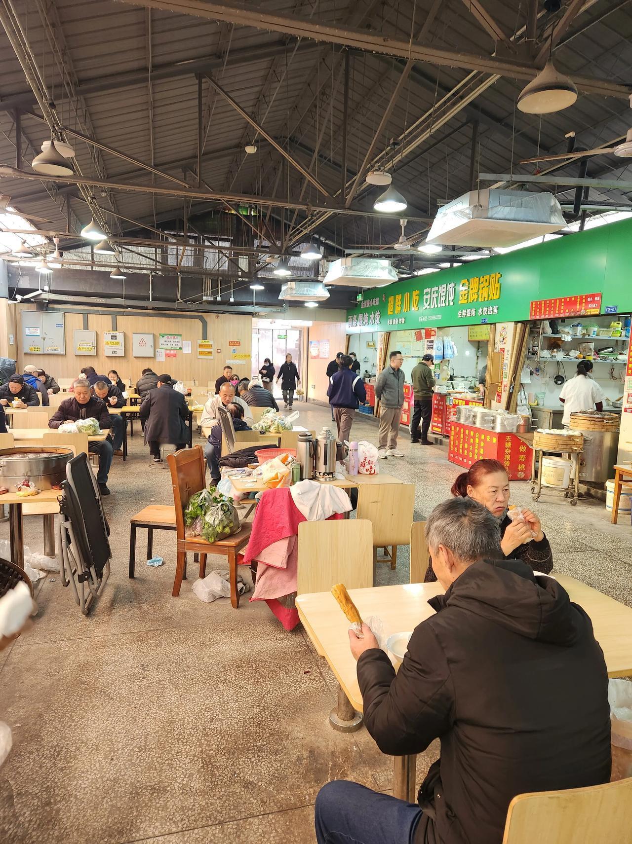 南京五所村菜场里面的早餐点，坐满了人。一碗豆腐脑，一根油条，一个茶叶蛋，一共6