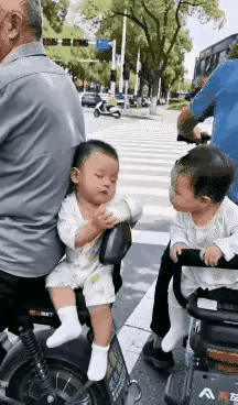 这两个小朋友真是够搞笑的了，一个在车上睡着了，手里还抱着奶瓶，一个嘴馋了，居然把