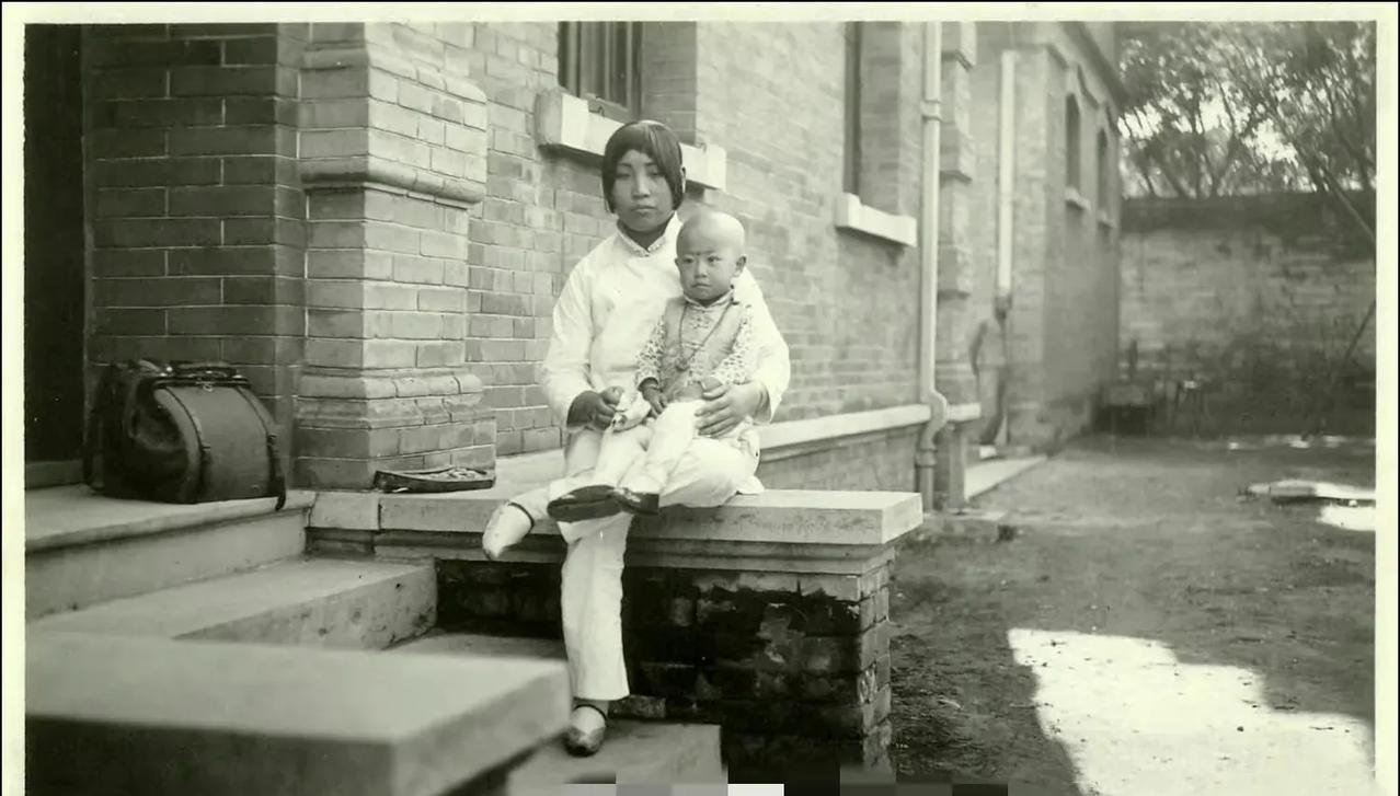 这是1917年，张勋复辟失败后，带着家人逃进了荷兰公使馆，他的姨太太廖清荷，怀里