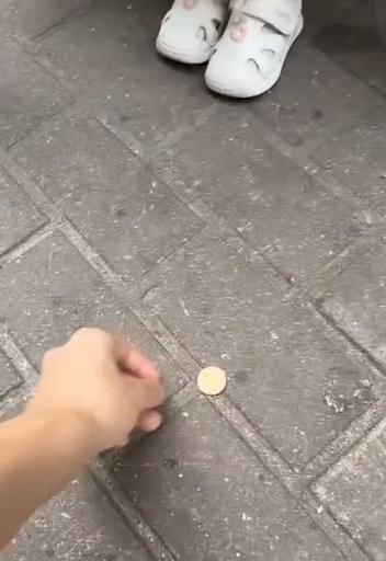 港灿又出毒招，只要看到有大陆游客在香港的街头蹲着，他们就向蹲着的游客扔硬币。