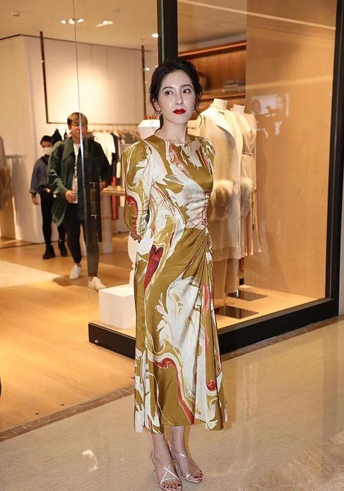  曾黎一袭油画印花长裙加身，裙上的色彩如同将艺术画布穿在身上，行走间尽显从容优雅