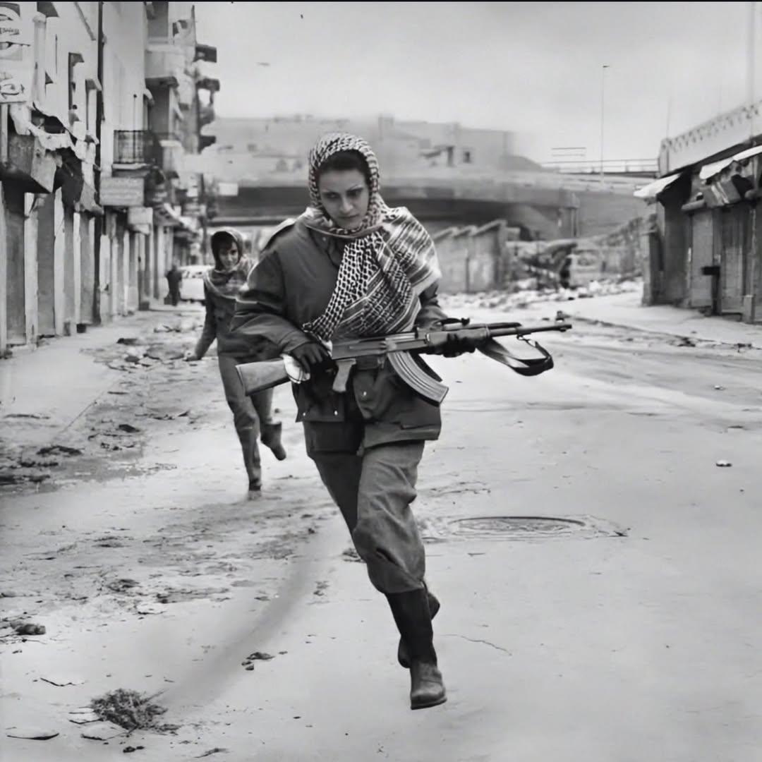由凯瑟琳·勒罗伊拍摄于1976年的黑白照片，捕捉了两名身披阿拉伯头巾、手持AK-