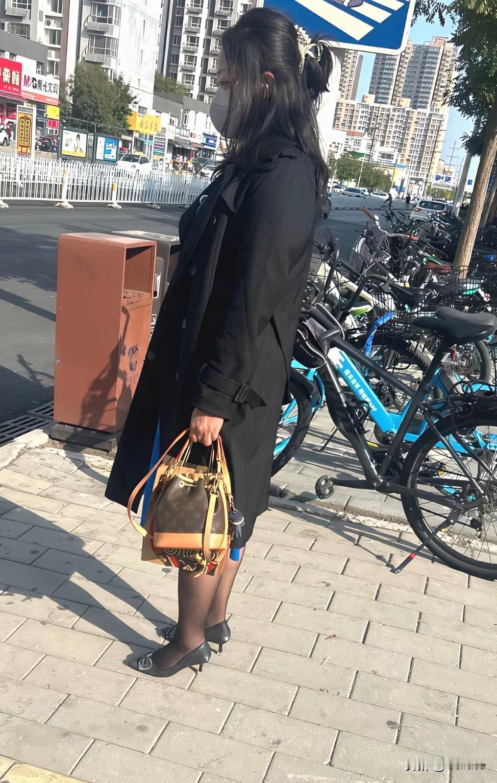 都市时尚穿搭，黑色大衣搭配复古手提包，尽显优雅气质。