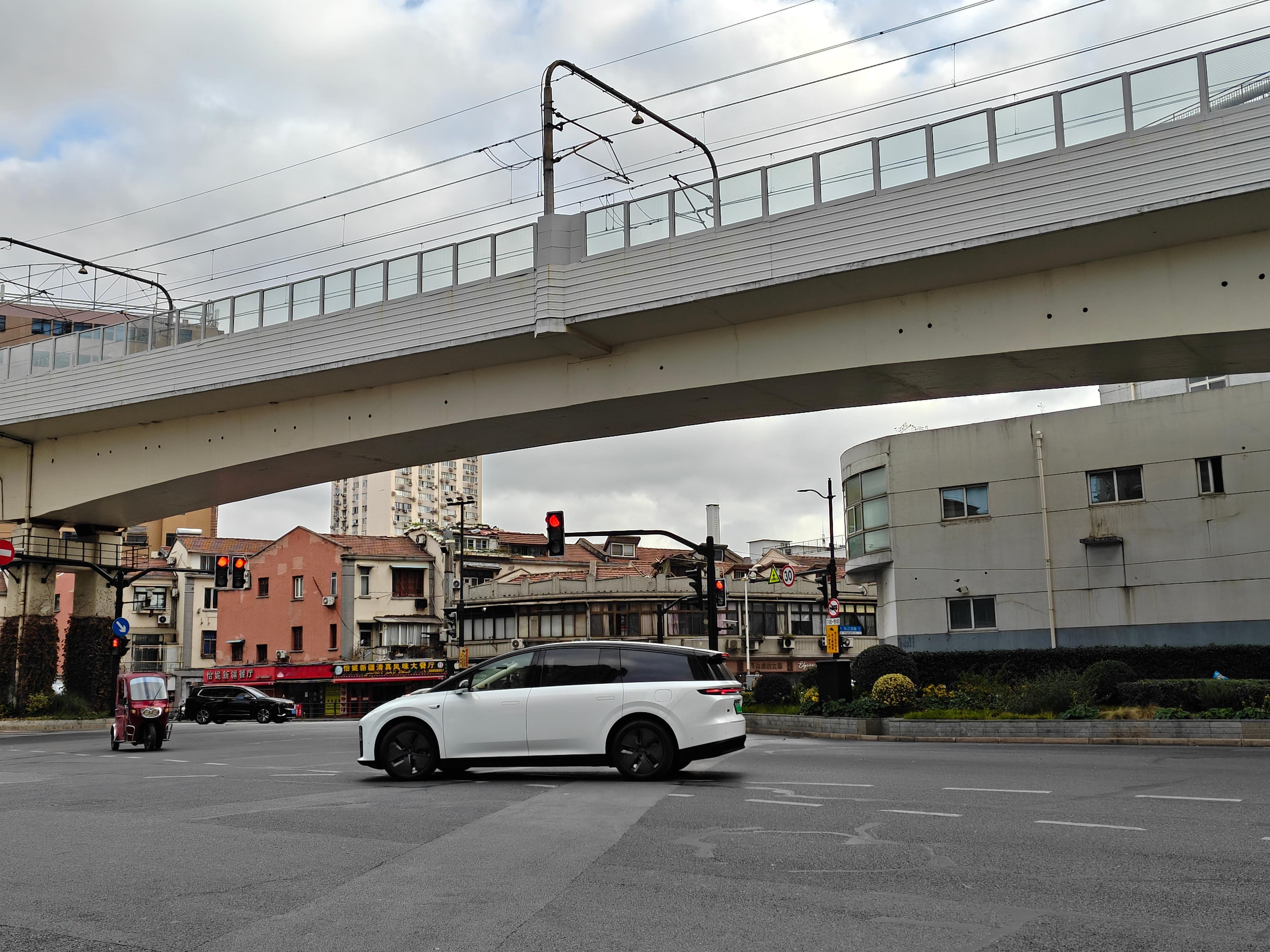 一早骑车，碰到一台开小蓝灯的理想i8，还是位女车主。这车从正面、斜侧面看显小，但