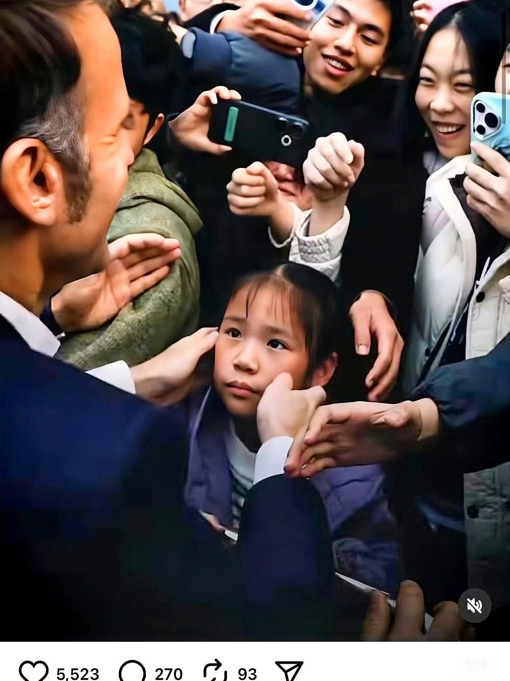 马克龙回国后，立马发了张照片，手捧着咱中国小孩的脸。背后，是乌泱泱的人群，一张