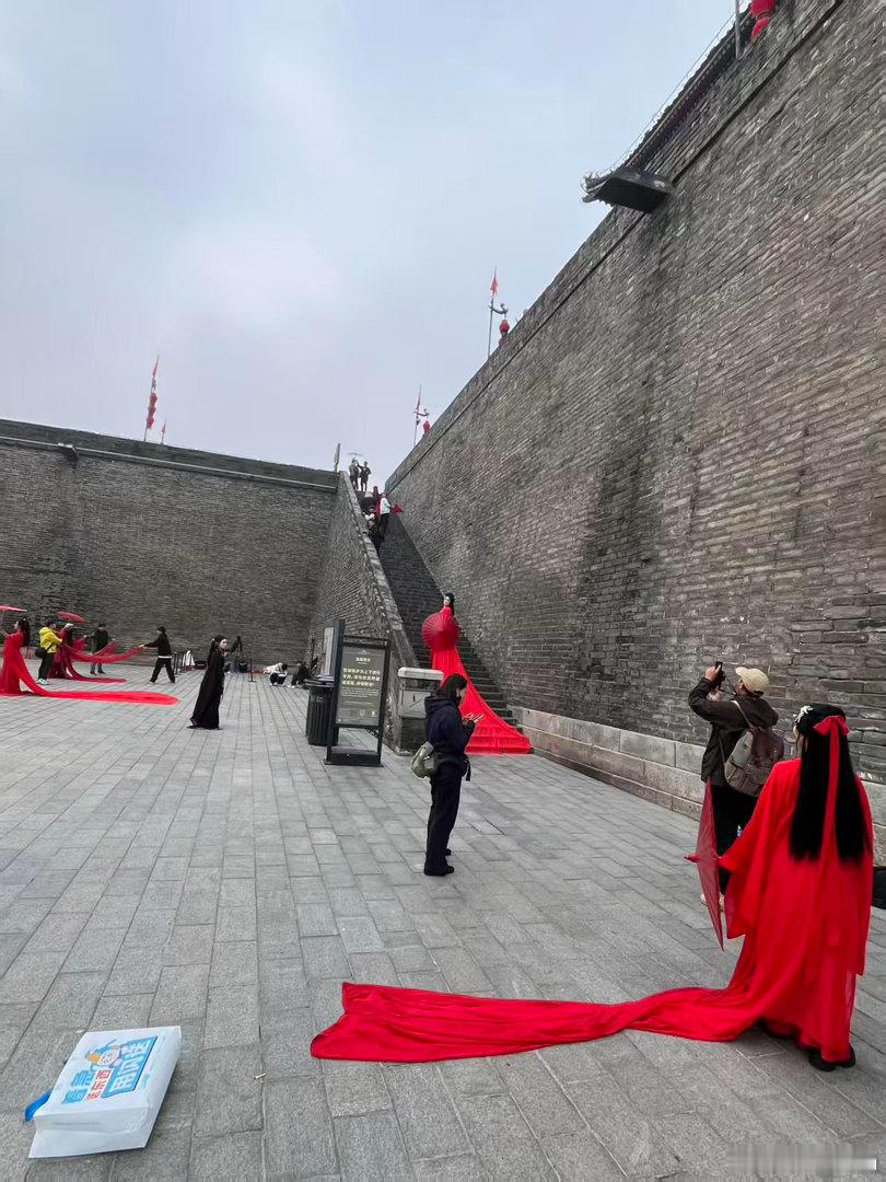 周生辰西安又下时宜了青砖城墙衬着成片红衣，随处可见打扮成十一的游客，人人都揣着