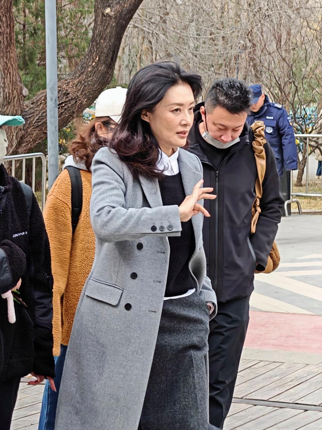 58岁周涛现身北京朗园游玩，她穿着灰色大衣和长筒靴，一头长卷发披肩，看起来贵气十