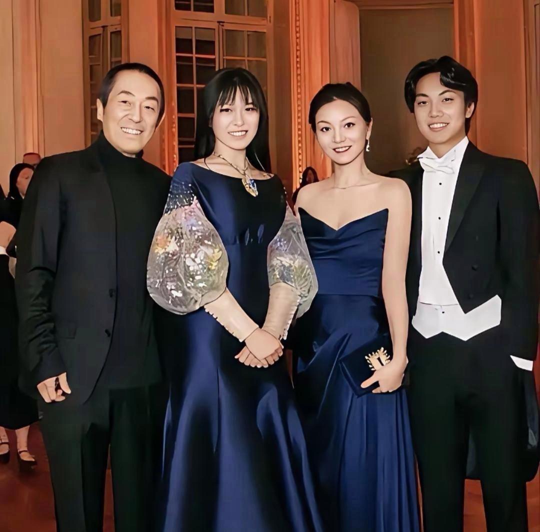 张艺谋一家四口的合影，女儿跟妈妈陈婷穿着同色系的礼服裙，身高比妈妈高，像张艺谋多