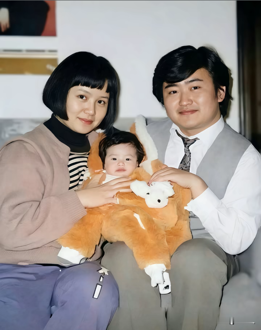 90年代，刘欢一家三口的合影。左边是妻子卢璐，怀里抱着的是女儿刘一丝。卢璐留着清爽短发，穿搭是典型的