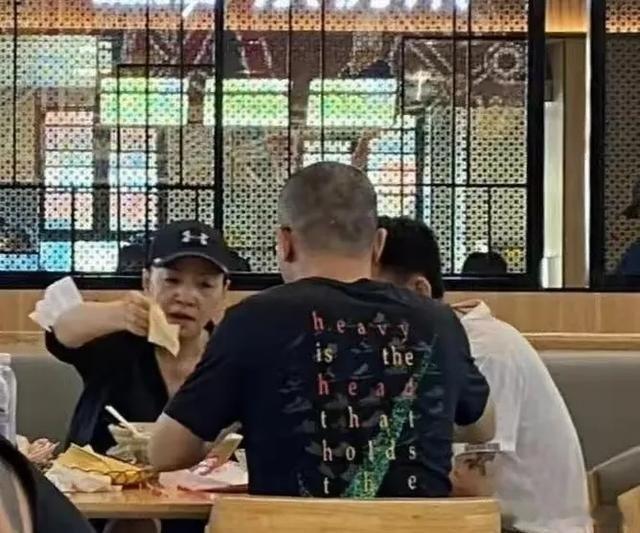 64岁宋丹丹一家六口游阿那亚，喜剧女王端着盘子给老公喂饭，网友：台上逗我们笑台下喂他吃，这反差谁扛得