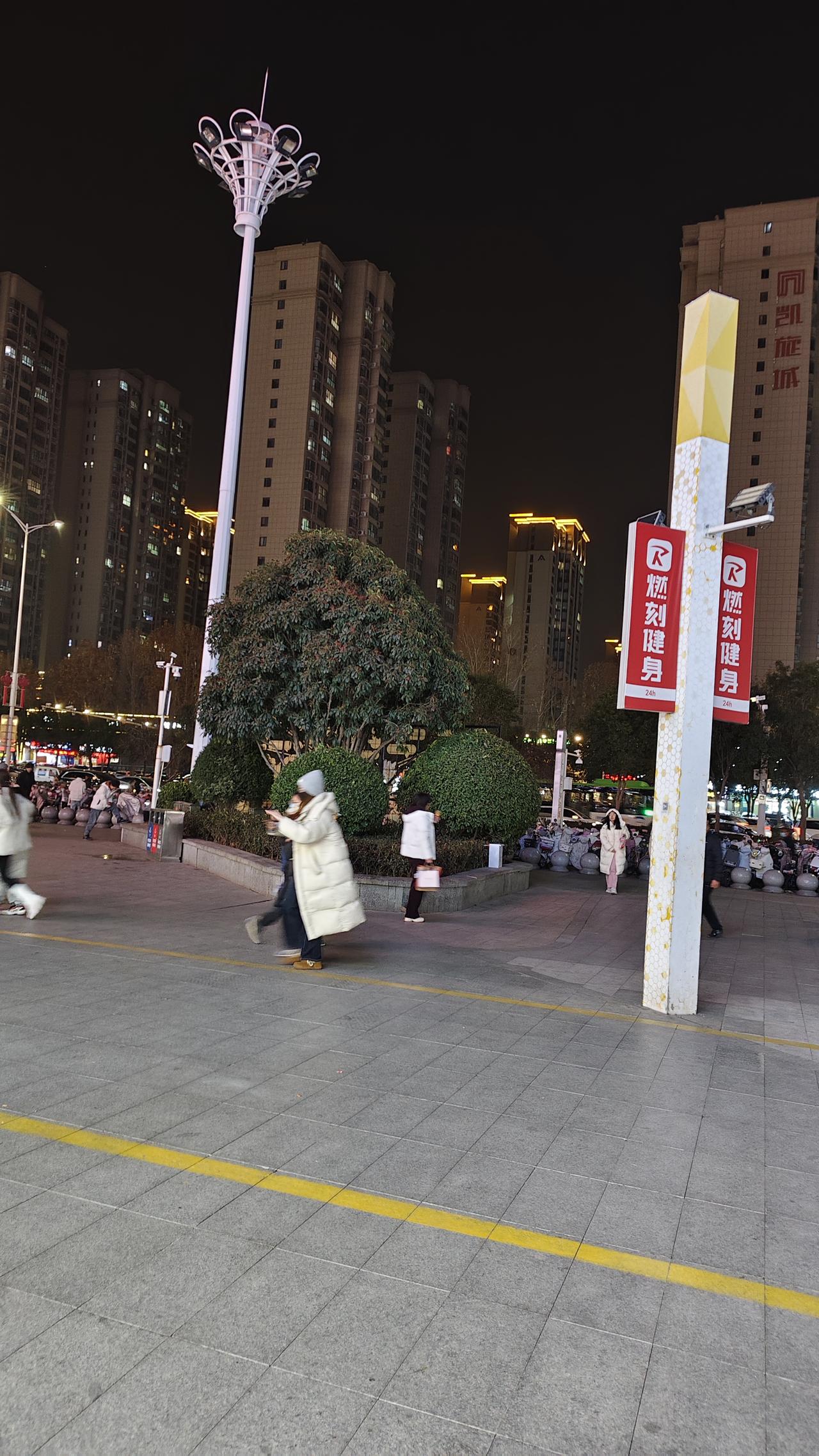 夜晚的街头，路灯把光线铺在灰色的地砖上，两道黄线顺着路面延伸开去。旁边的白色