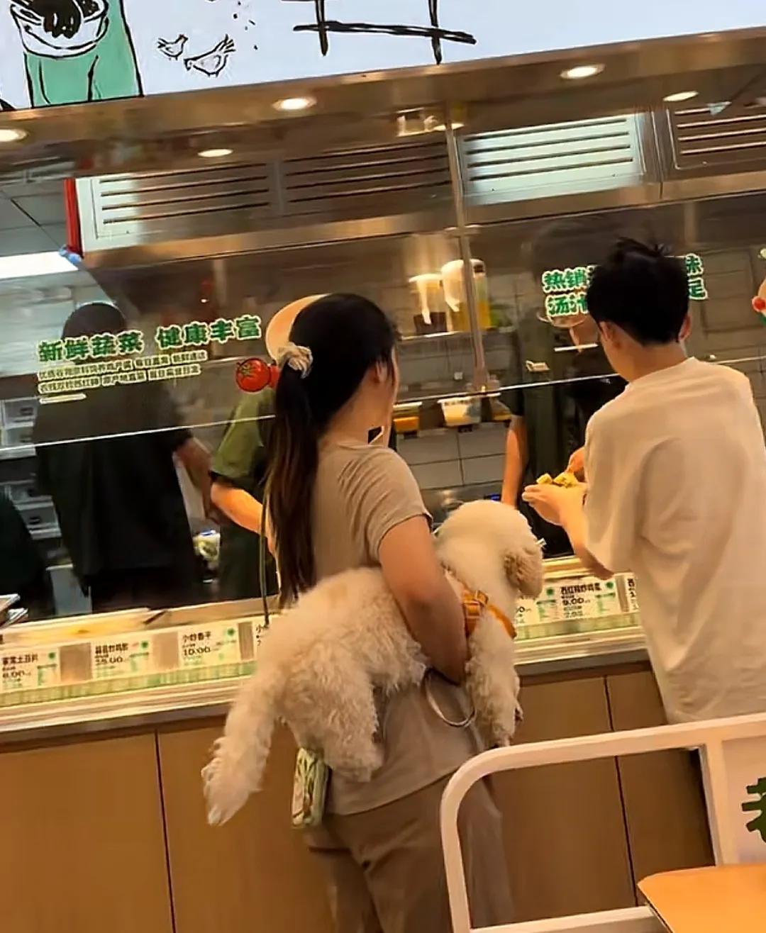 苏州。女子抱狗进入知名快餐店用餐，用摸狗的手拿餐具和碗筷，店员却置若罔闻。禁