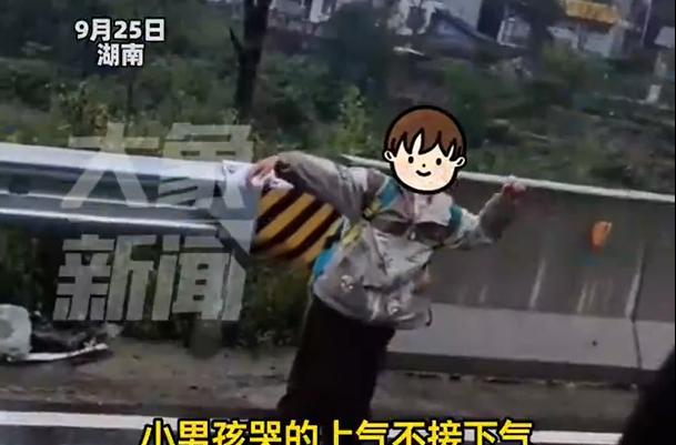 湖南，一名男子开车行驶在快车道上，当时正在下雨，男子突然看到路边有一个五六岁的小