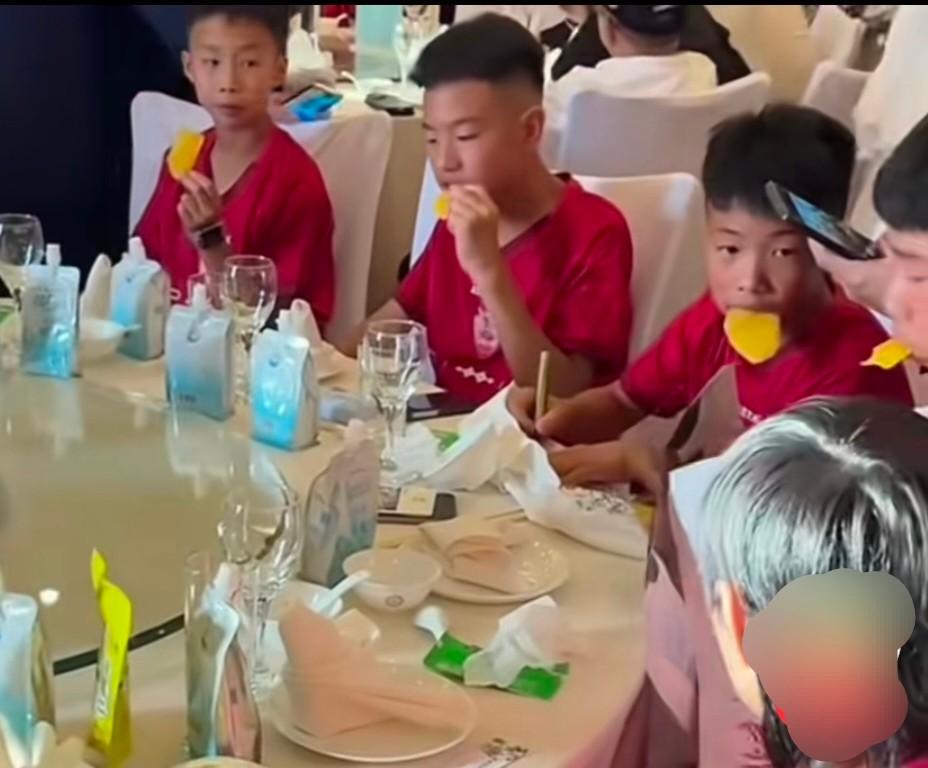 庆功宴上，菜还没上，孩子们先拆开了自带的零食。大口吃着，没人管规矩。成年人呢，