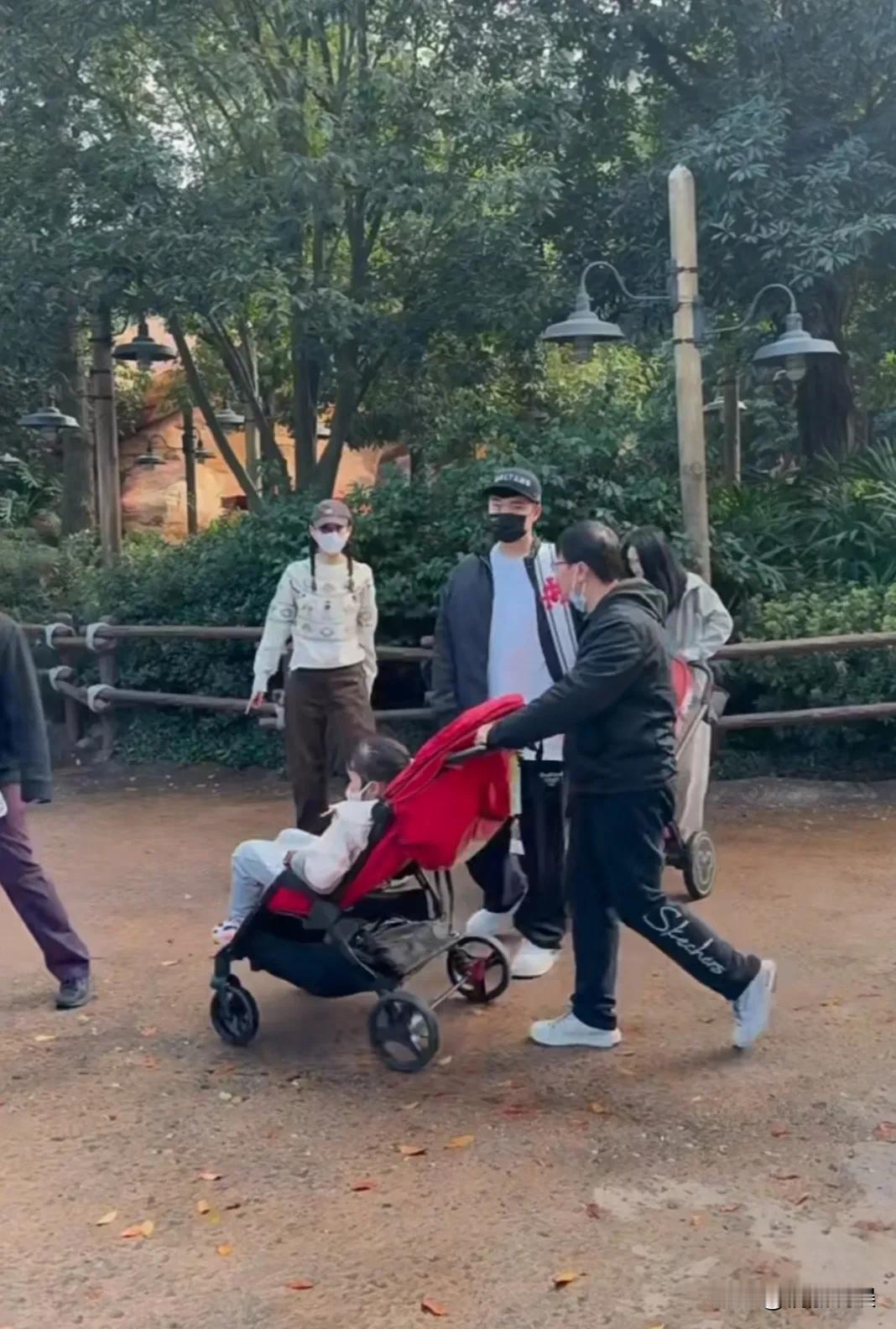 陈赫带着老婆孩子现身上海迪士尼。夫妻俩都戴着口罩，两个孩子都坐在小推车上，两个