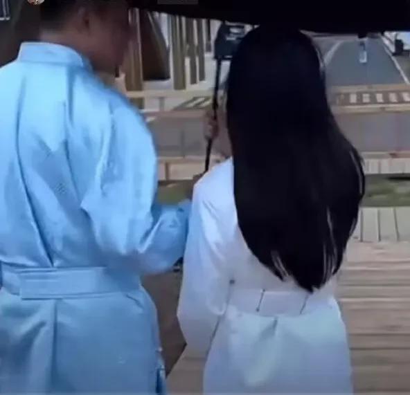 来到了草原，玥儿穿了一套白色的长裙。小汪总为她打着伞，粉丝们看到她的背影，大家都