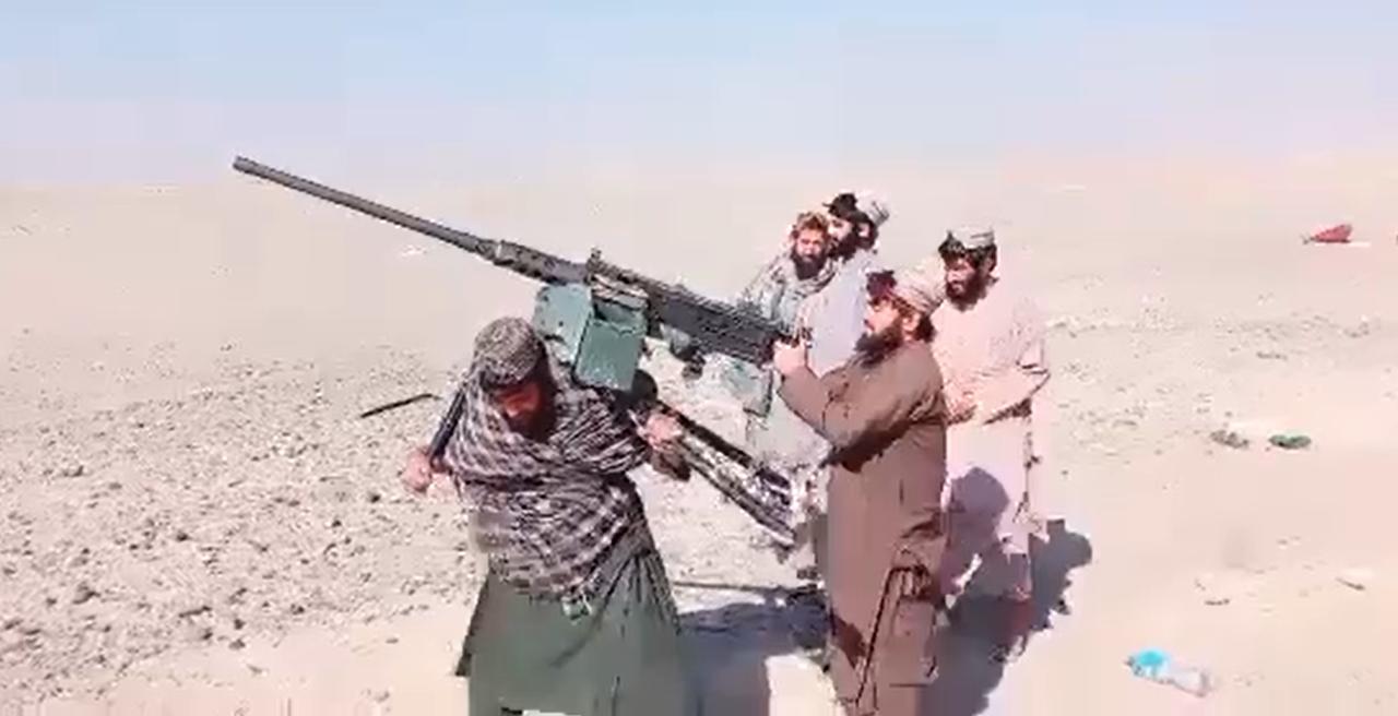 视频片段显示，武装的阿富汗战士在崎岖的地形中携带重型武器进行机动，这个12.7M