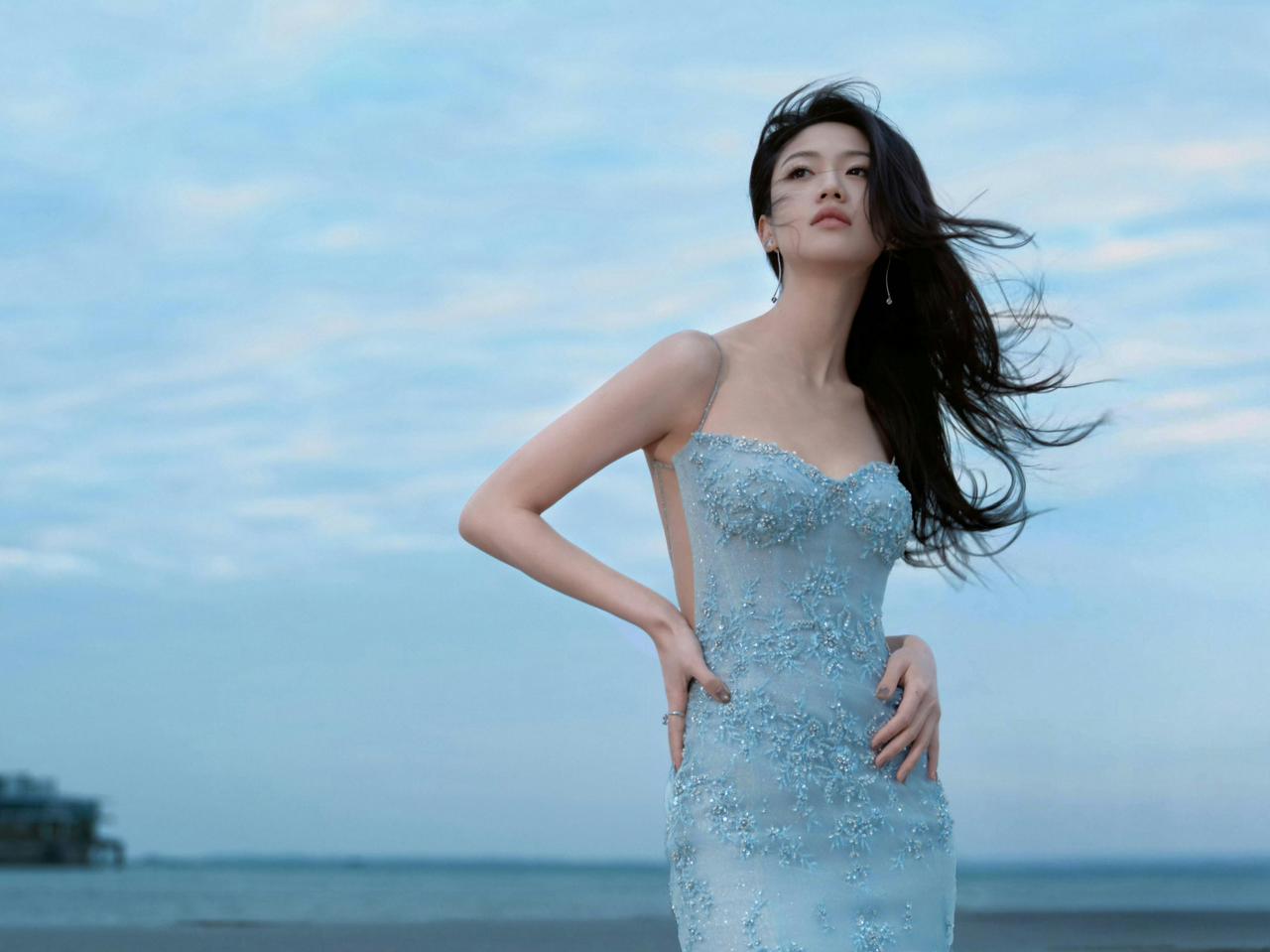 当淡蓝的裙裾漫过沙滩，海便成了最温柔的幕布。风是即兴的导演，将发丝、裙摆与浪涛编