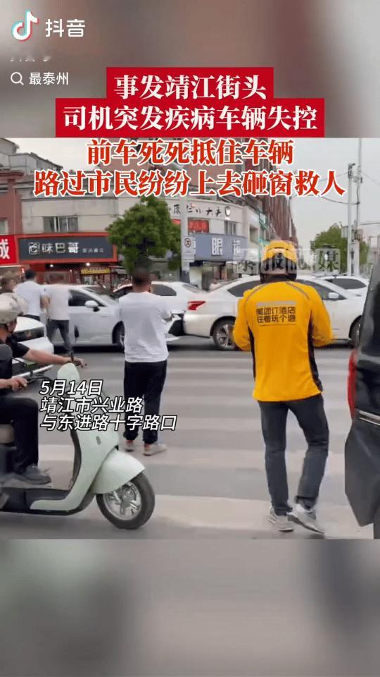 江苏靖江市，5月14日，一处人流极大的红绿灯路口。女子正驾车等候，车尾突遭撞击，