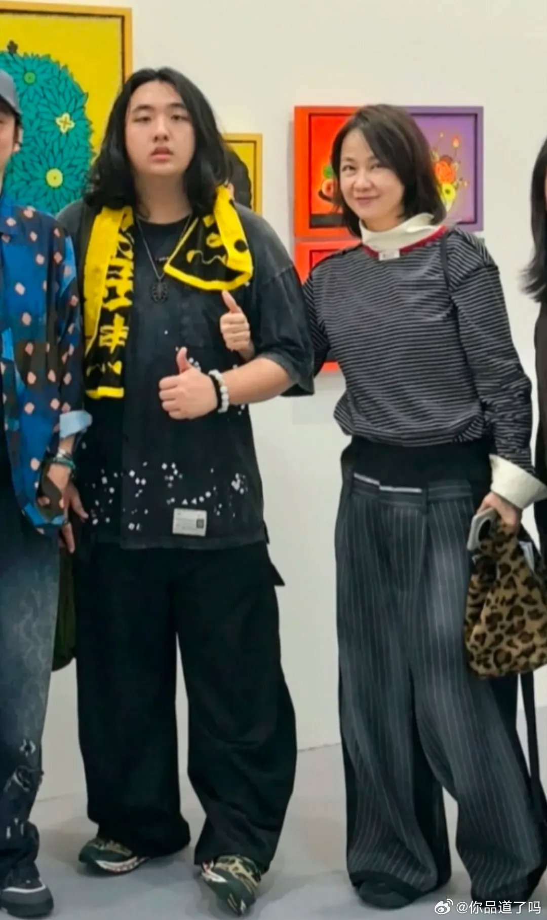 吴镇宇的儿子费曼与妻子王丽萍一同现身巴塞尔艺术展。五十多岁的王丽萍身形高挑，脸部