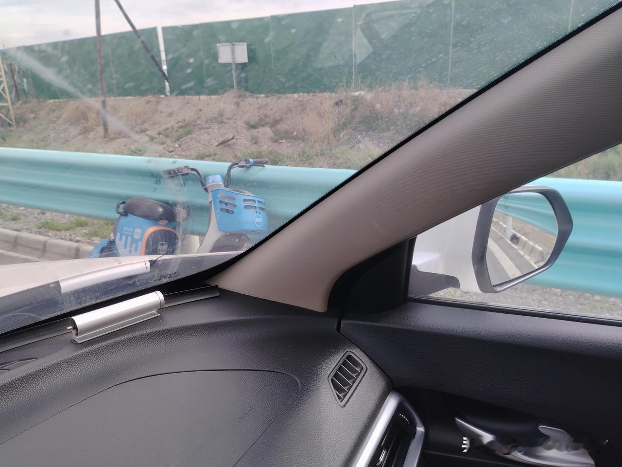 从车窗看出去，路边有辆蓝色电动车，它叫哈啰共享电车，是给我们提供便利的，但有些没