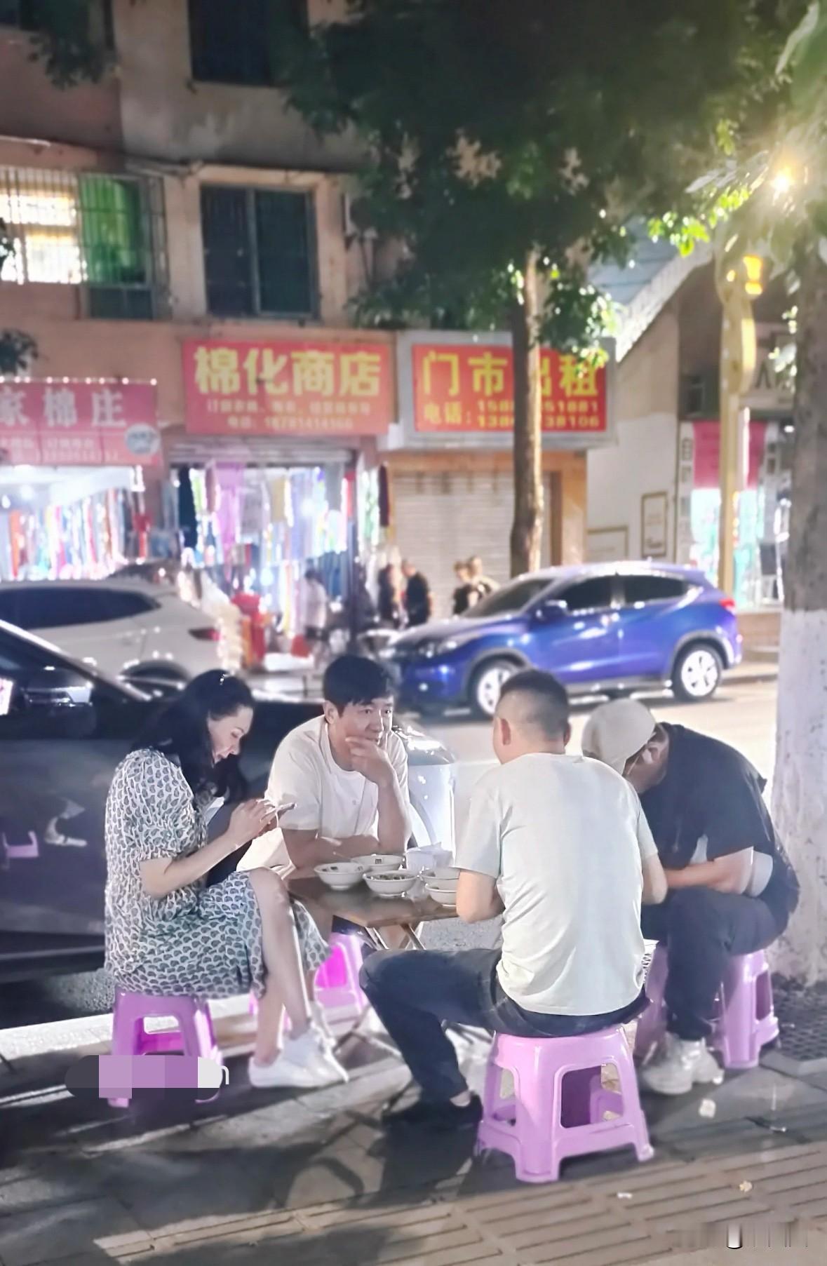 网友偶遇郭晓东程莉莎夫妇吃路边摊，超接地气！程莉莎翘着二郎腿低头看手机，郭晓东