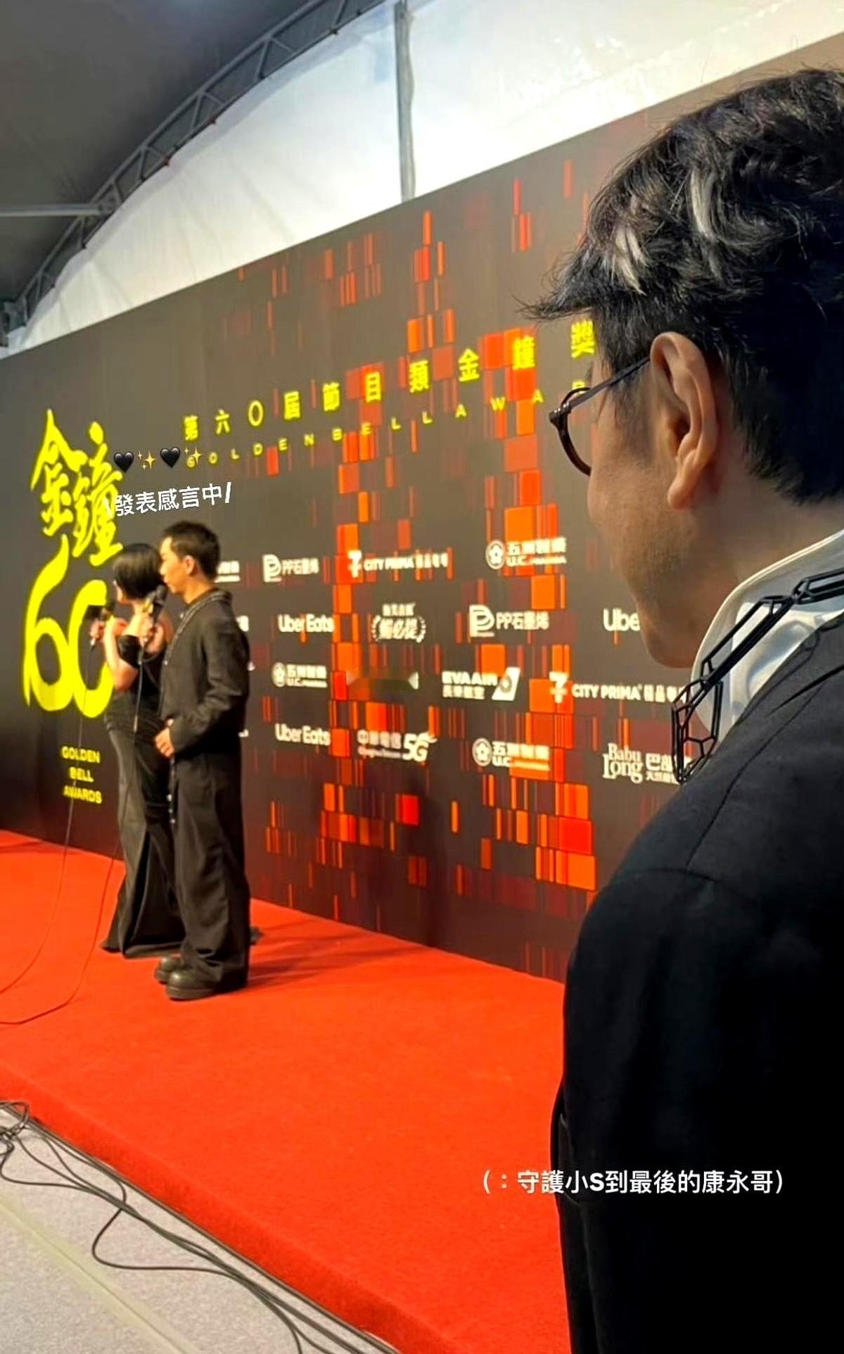 后台，小S拿了奖，被一群记者围着。但你把照片放大，往后看，乌泱泱的人群里，站着