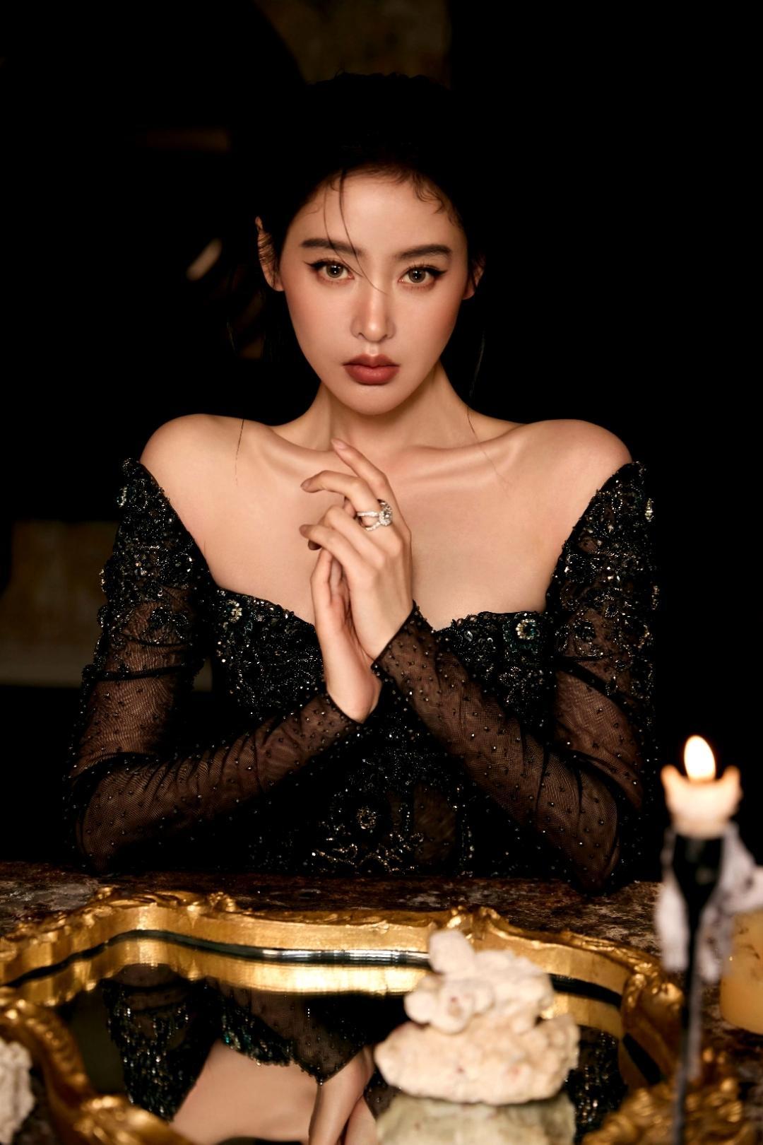 暗夜鎏光，魅色天成。张天爱置身复古光影之中，一袭黑纱镶钻露肩礼裙，冷艳矜贵又自带