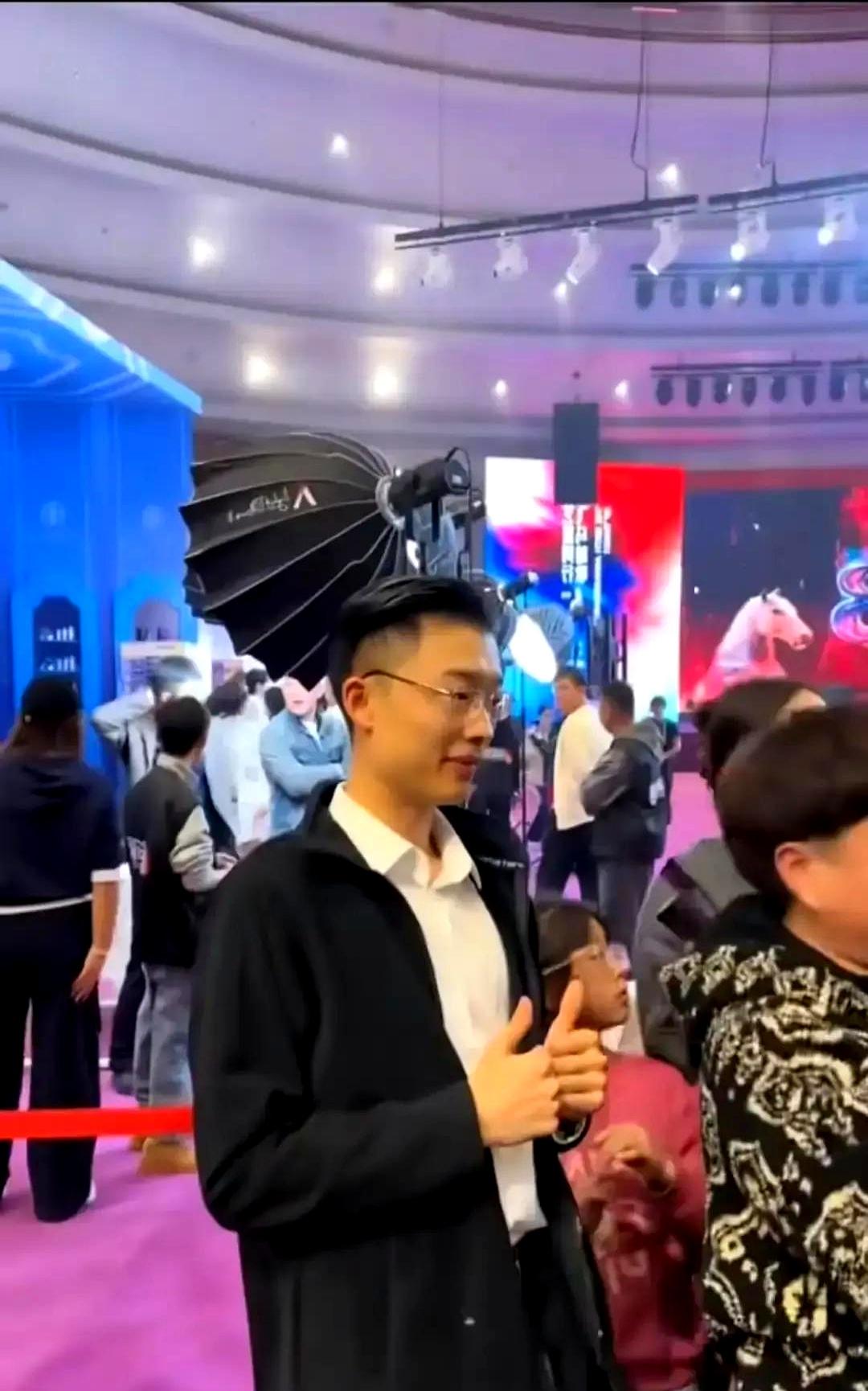 郭有才在南京路演被保安催着走。他淋着雨给排队的人签字，连个撑伞的助理都没