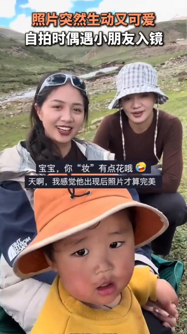 照片突然生动又可爱，自拍时偶遇小朋友入镜。近日，西藏那曲。宝宝，你"妆"有点花