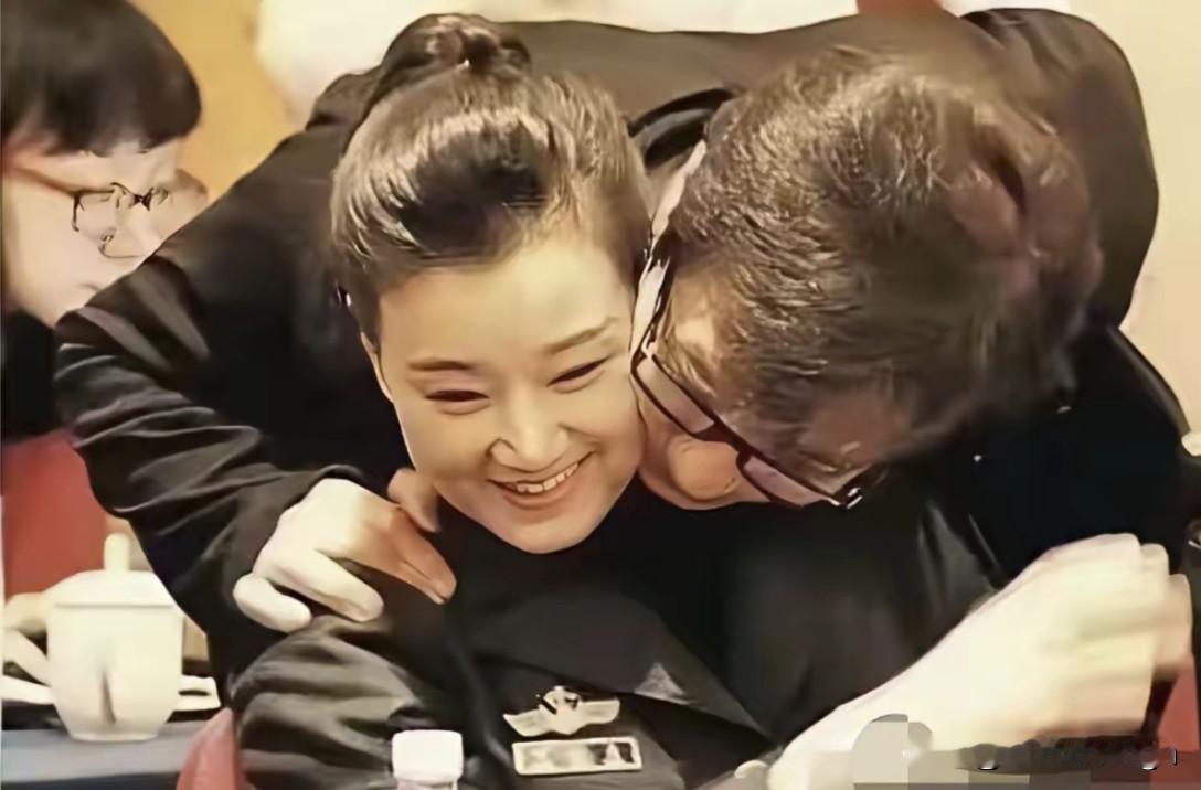 这是早年两会开会休息的时候，成龙忽然从身后俯身过来，伸手搭着宋祖英肩膀凑脸贴近。