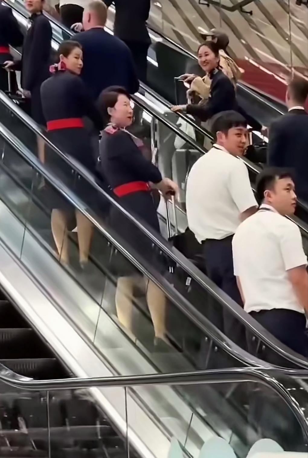 一个身穿红色职业装的阿联酋空姐，瞬间成了机场的焦点。同行们向她投来了齐刷刷的